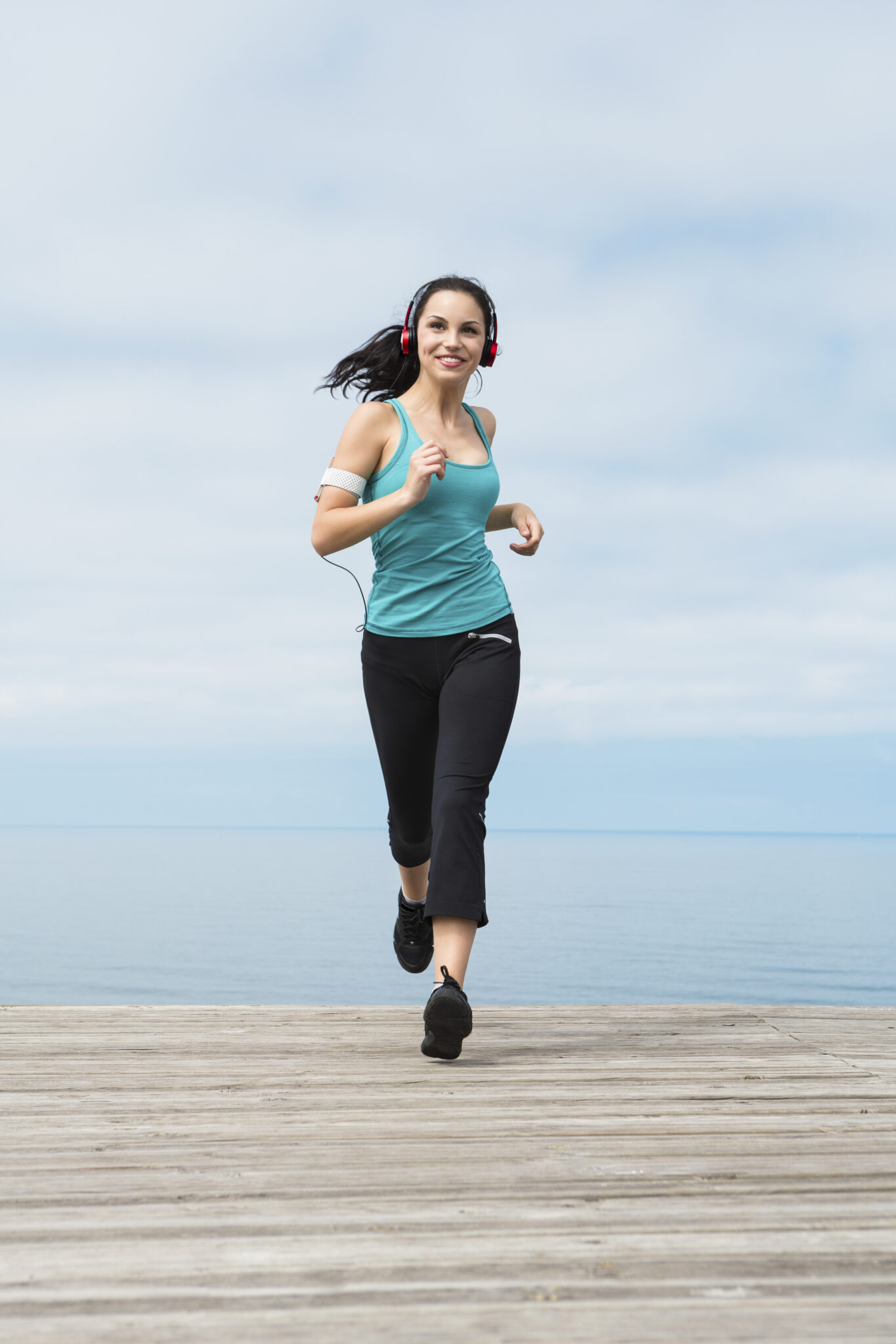 Beautiful,Young,Woman,Jogging,On,A,Boardwalk,And,Listen,Music